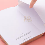 Close up of open back page pocket of Tsuki ‘Suzume’ Limited Edition Bullet Journal with free gift on coral pink background