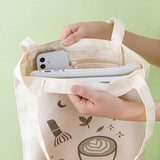 Close up of the inside of Tsuki ‘Matcha Matcha’ Tote Bag held in hands with laptop and mobile phone with inside zippable pocket in matcha green background