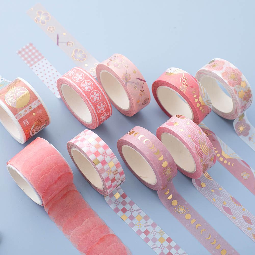 Close up of Tsuki 'Sakura Edition' Washi Tape Set rolled out on light blue background