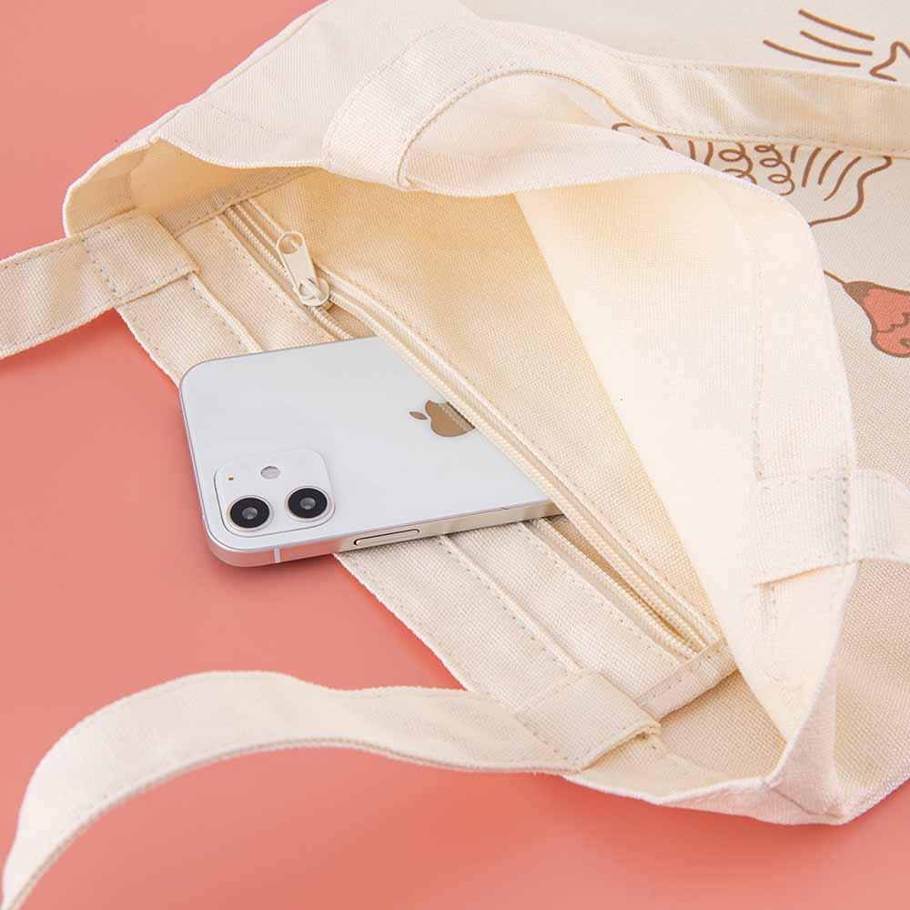 Close up of Tsuki ‘Moonflower’ Limited Edition Tote Bag with phone inside on coral pink background