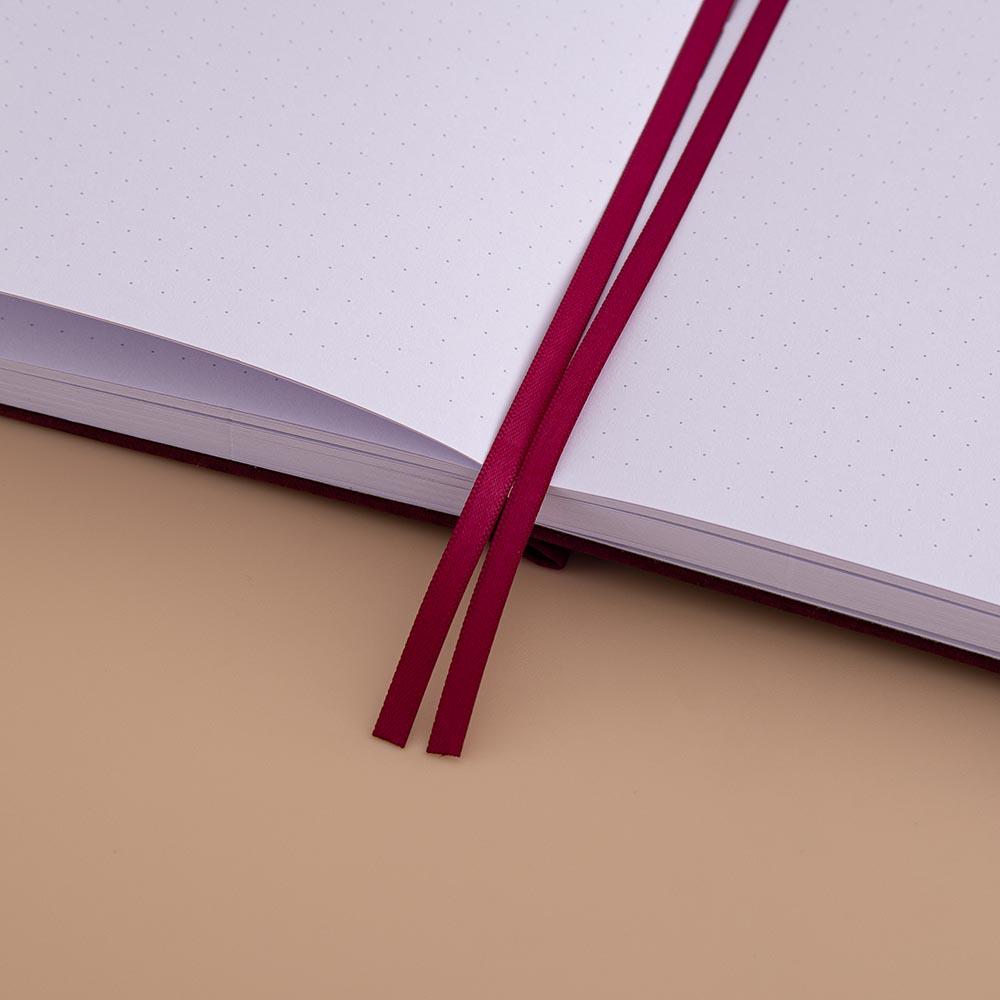 Close up of open page spread of Tsuki ‘Kinoko’ Limited Edition Bullet Journal with two bookmark ribbons on beige background