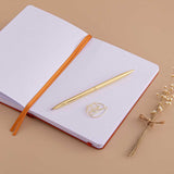 Open page spread of Tsuki ‘Kitsune’ Limited Edition Fox Bullet Journal with free paperclip gift with gold pen and dried flowers on beige background