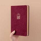 Tsuki Kraft Paper Limited Edition Bullet Journal in Kinoko held in hand at spine angle in beige background