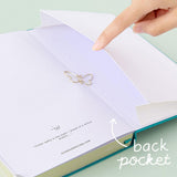Close up of open back page pocket of Tsuki Teal Sky ‘Flutter + Dream’ Limited Edition Bullet Journal by Notebook Therapy x Pelinkan with free butterfly bookmark gift held in hand on mint background
