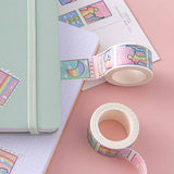 Close up of Tsuki Rainbow Pride Washi Tape on open notebook page with Tsuki Pastel Edition mint matcha bullet journal and postcard on light pink background