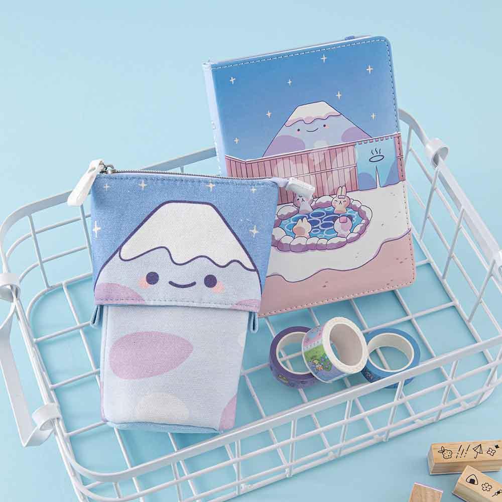 Tsuki ‘Four Seasons’ Fuji Pop-Up Pencil Case by Notebook Therapy x Milkkoyo with Tsuki ‘Four Seasons: Winter Edition’ Bullet Journal and Tsuki ‘Four Seasons’ Washi Tapes in white basket with Tsuki ‘Four Seasons’ Bullet Journal stamps on light blue background