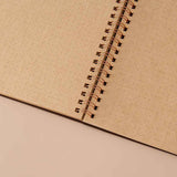 Close up of open page spread of Tsuki ‘Maple Dreams’ Kraft Paper Ringbound Bullet Journal on beige background