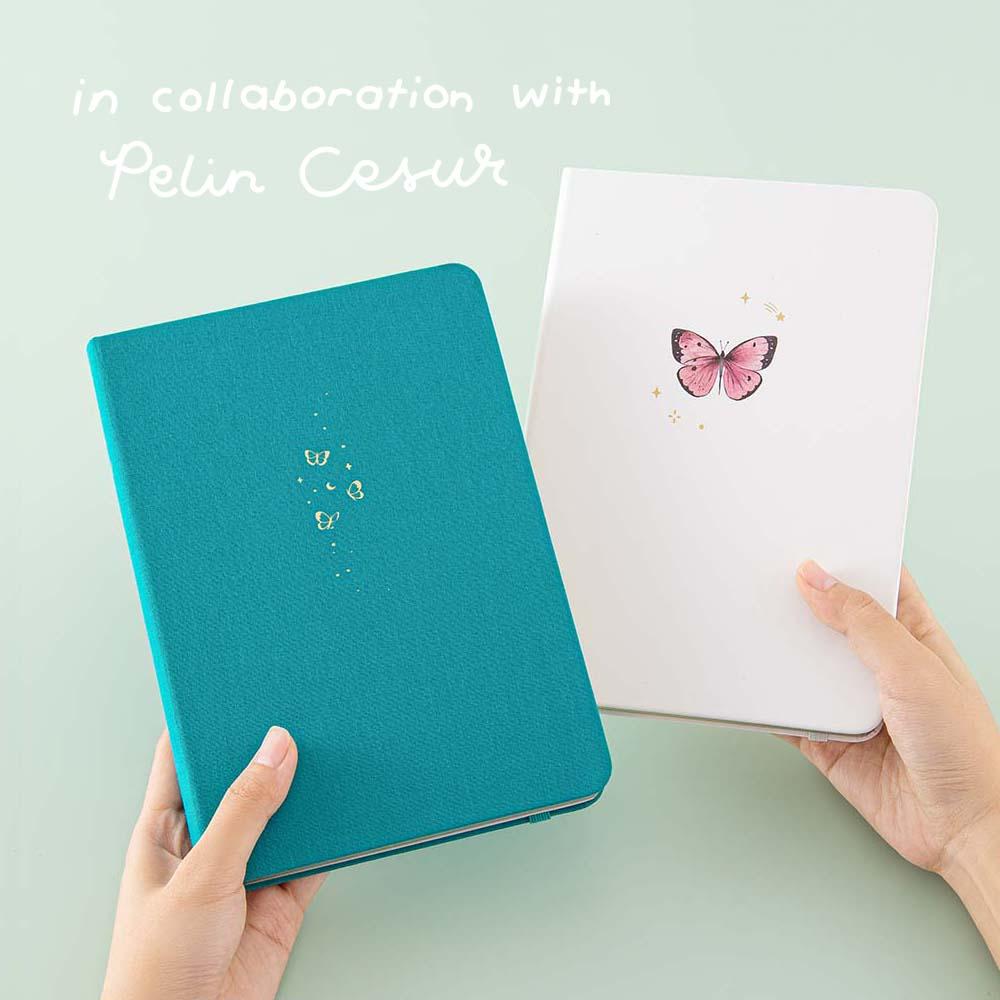 Tsuki Teal Sky ‘Flutter + Dream’ Limited Edition Bullet Journal by Notebook Therapy x Pelinkan and Tsuki Cloud White ‘Flutter + Dream’ Limited Edition Bullet Journal by Notebook Therapy x Pelinkan held in hands in mint background