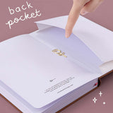 Open Tsuki ‘Vintage Rose’ Limited Edition Bullet Journal with open back page pocket held in hand with free paper clip rose gift on mauve background