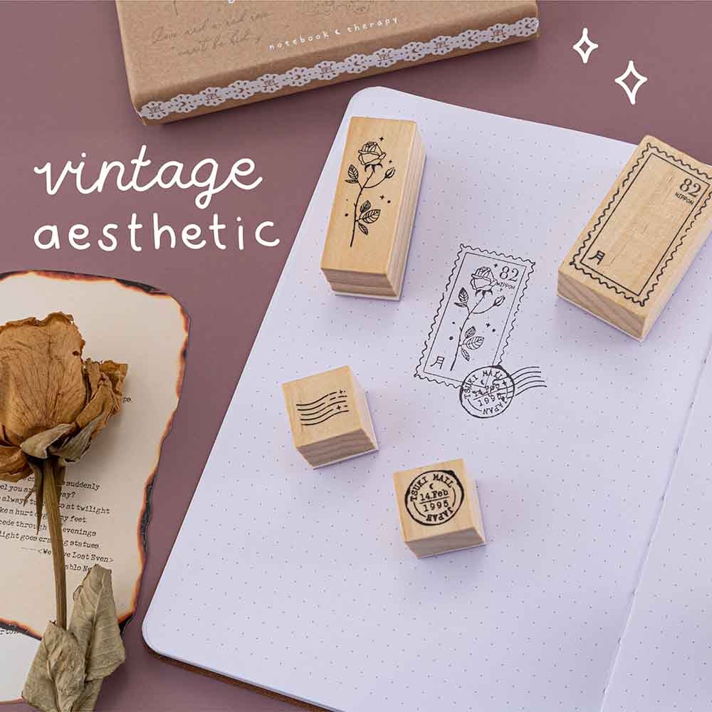 Tsuki ‘Vintage Rose’ Bullet Journal Stamp Set with vintage aesthetic on open Tsuki ‘Vintage Rose’ Limited Edition Bullet Journal with burnt paper and dried roses on mauve background