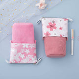 Tsuki 'Sakura Edition' Pop-Up Pencil Case in blush pink and petal pink with white pen and sakura blooms on sparkly netting on light blue background