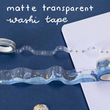 2 rolls of transparent matte PET washi tape rolls on bullet journal with the words ‘matte transparent washi tape’ written in white
