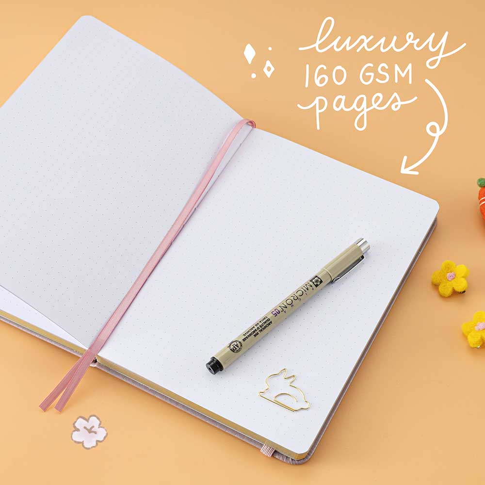 Open Tsuki Blush Pink ‘Bunny Blush’ Limited Edition Bullet Journal designed with Blossom Bujo with luxury 160GSM pages with free bunny bookmark with pen and felt flowers on apricot background
