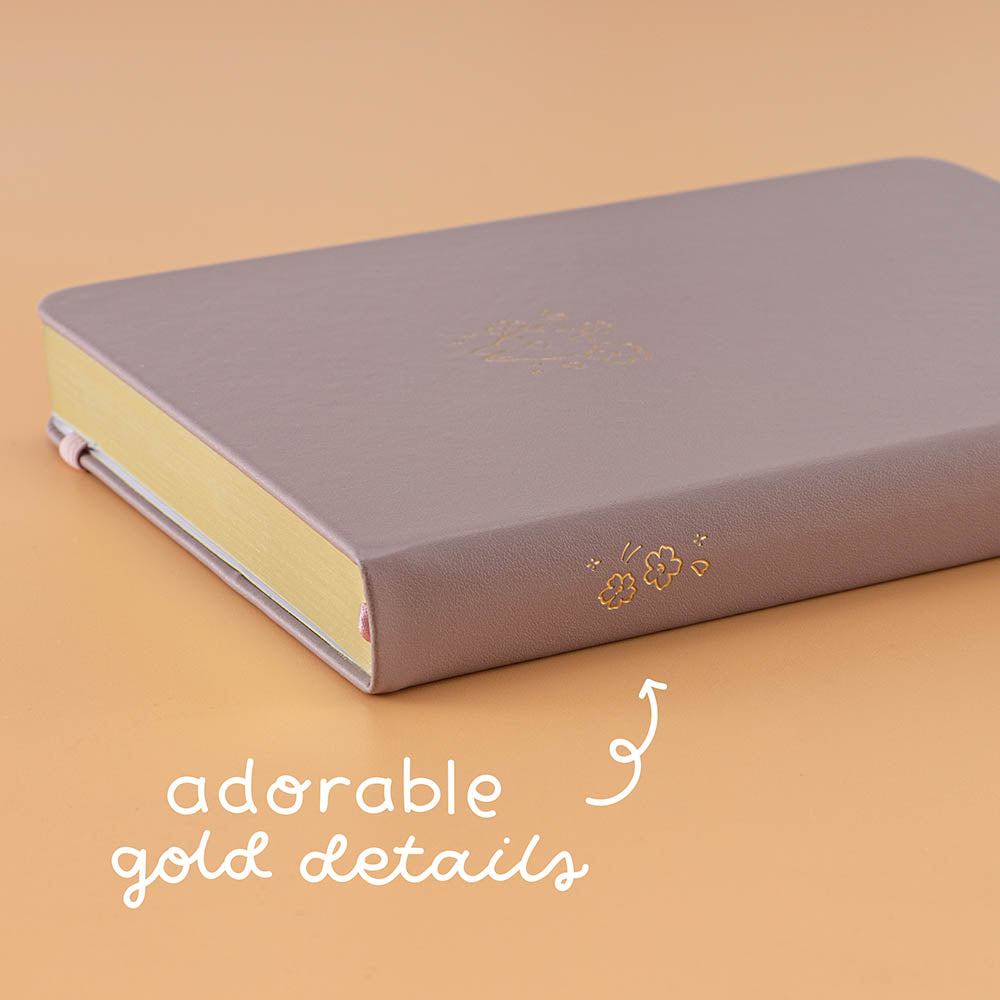 Close up of Tsuki Blush Pink ‘Bunny Blush’ Limited Edition Bullet Journal designed with Blossom Bujo with adorable gold details on apricot background