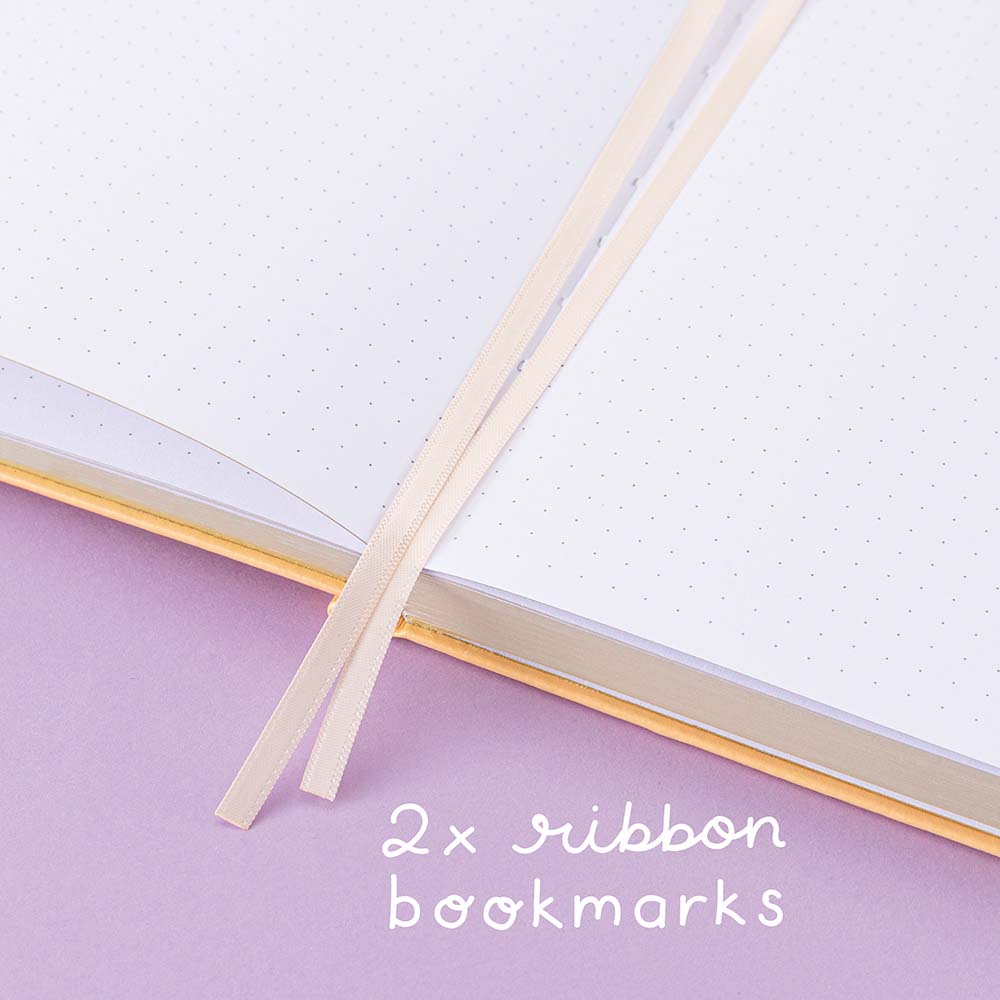 Close up of open Tsuki Honey Butter ‘Bunny Blush’ Limited Edition Bullet Journal designed with Blossom Bujo with two bookmark ribbons on lilac background
