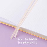 Close up of open Tsuki Honey Butter ‘Bunny Blush’ Limited Edition Bullet Journal designed with Blossom Bujo with two bookmark ribbons on lilac background