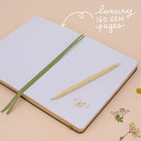 Notebook laid flat on beige background with the words ‘luxury 160gsm pages’ in white lettering