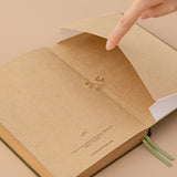 Kraft paper notebook and a hand opening the expandable back pocket