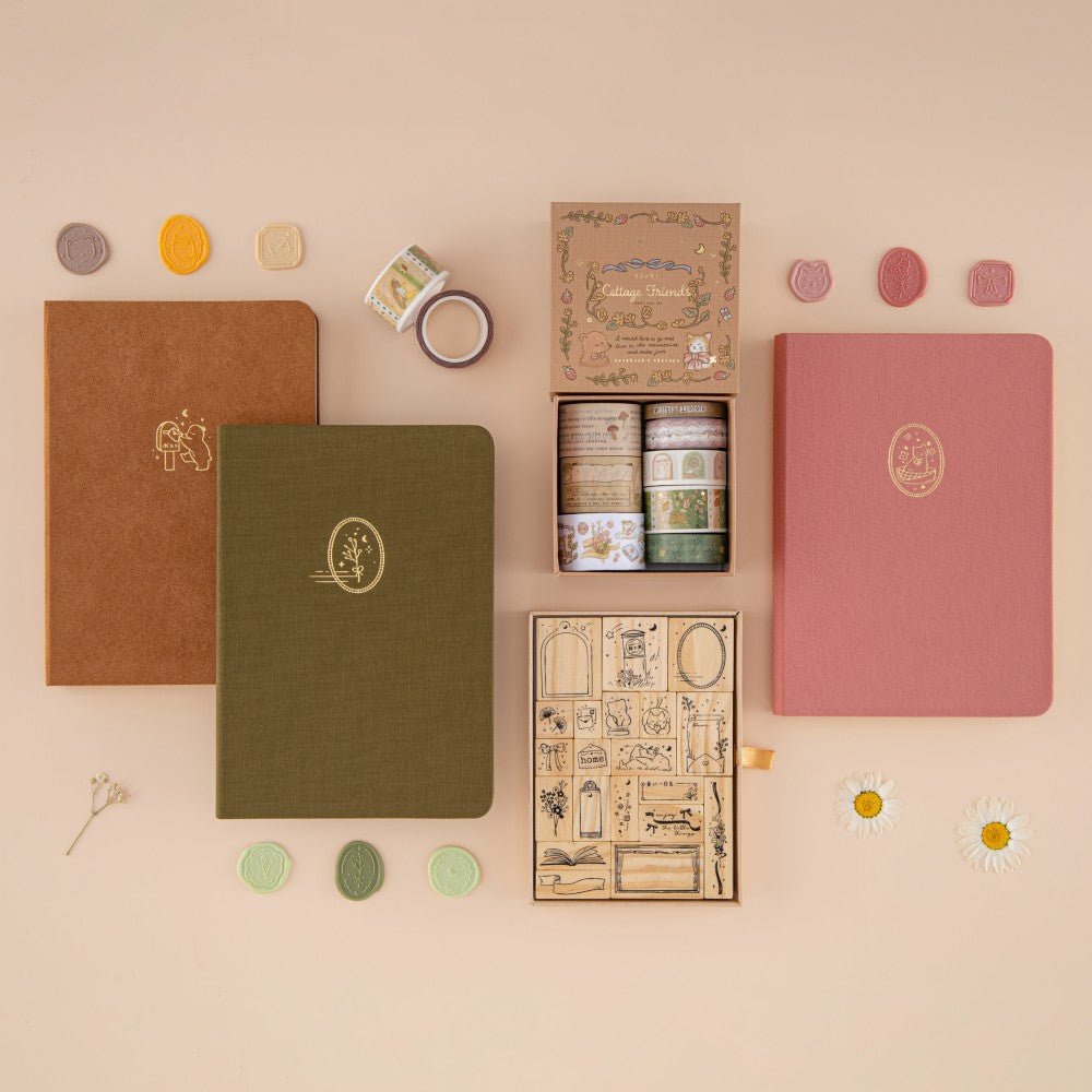 Cottage Friends collection flatlay with brown bear bullet journal, green leaf bullet journal, washi tapes, stamp set and pink cat bullet journal