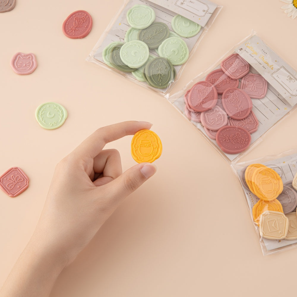 Hand holding yellow wax seal sticker