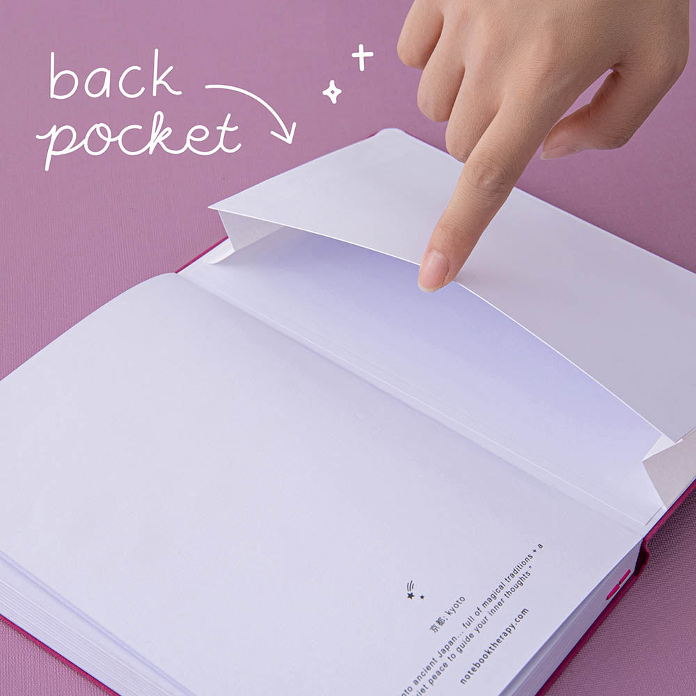 Finger lifting up the back pocket of a bullet journal