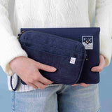 Model holding both Cloud Dreamland travel pouch and notebook pouch