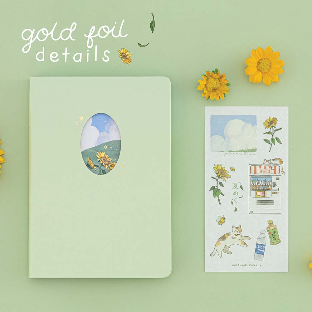 Tsuki Four Seasons Summer Collectors Edition 2022 sage bullet journal notebook on sage background with sunflower decoration and a sticker sheet